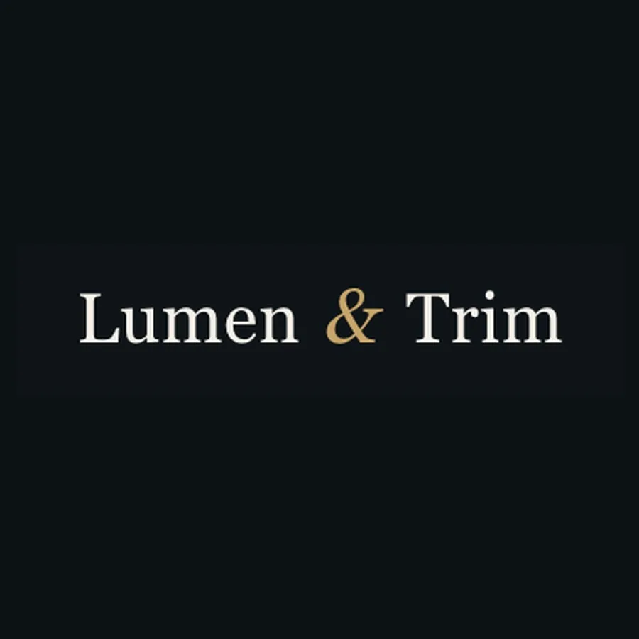 The Lumen and Trim wordmark: a high-contrast serif in warm white on near-black, with the ampersand set in gold.