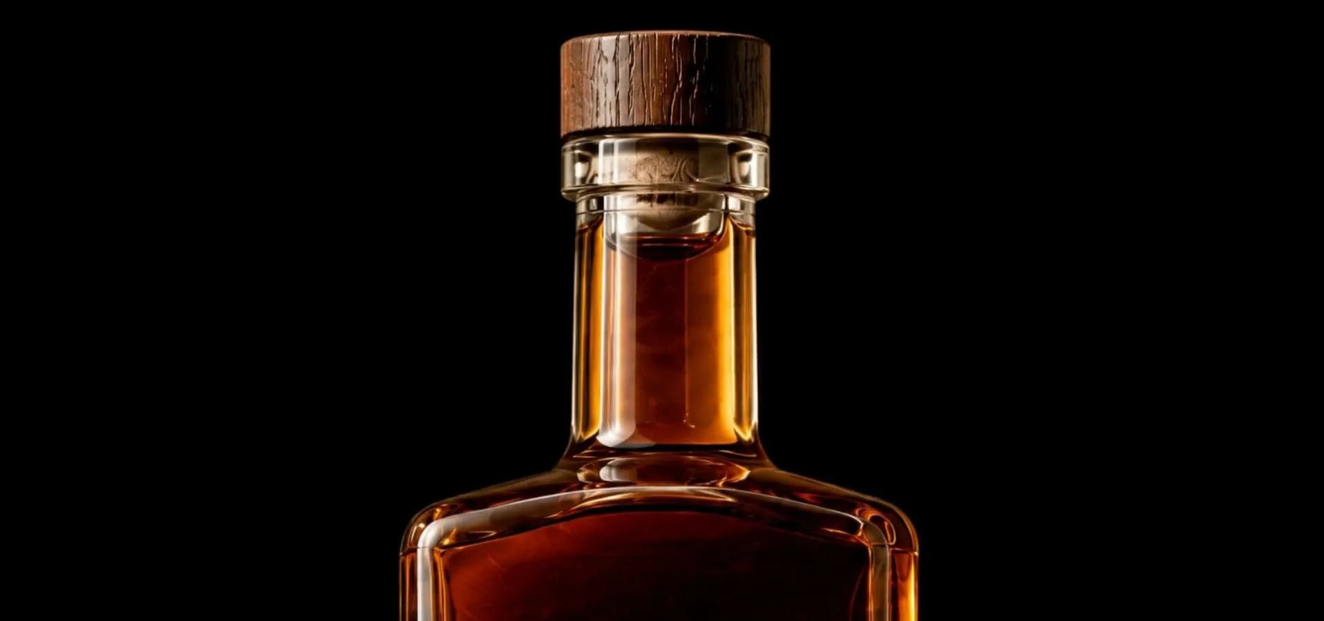 Macro on the neck and shoulder of a square whisky bottle with a dark wooden cap, lit by one hard rim light in a black void.